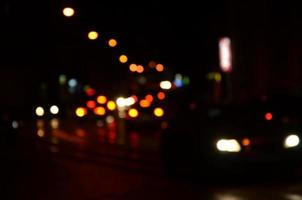 Blurred night scene of traffic on the roadway. Defocused image of cars traveling with luminous headlights. Bokeh Art photo