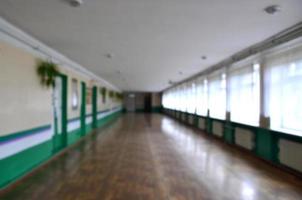 The blurred image of gloomy corridor of a neglected public building. Defocused picture of a public space in a poor residential high-rise building photo