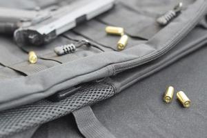 9mm bullets and pistol lie on a black tactical backpack photo