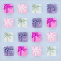 Piles of a small colored gift boxes with ribbons lies on a violet background photo