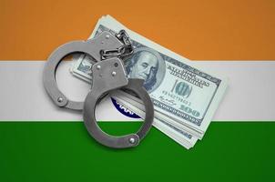 India flag with handcuffs and a bundle of dollars. Currency corruption in the country. Financial crimes photo