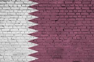 Qatar flag is painted onto an old brick wall photo
