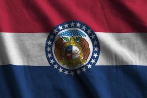 Missouri US state flag with big folds waving close up under the studio light indoors. The official symbols and colors in banner photo