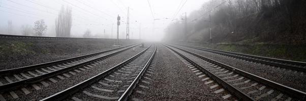 The railway track in a misty morning. A lot of rails and sleepers go into the misty horizon. Fisheye photo with increased distortion