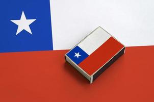 Chile flag is pictured on a matchbox that lies on a large flag photo