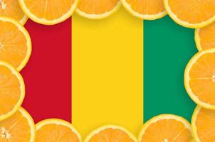 Guinea flag in fresh citrus fruit slices frame photo