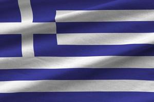 Greece flag with big folds waving close up under the studio light indoors. The official symbols and colors in banner photo