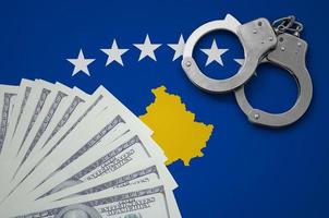 Kosovo flag with handcuffs and a bundle of dollars. The concept of illegal banking operations in US currency photo