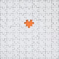 The texture of a white jigsaw puzzle in an assembled state with one missing element forming an orange space photo