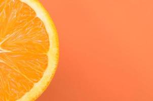 Top view of a one orange fruit slice on bright background in orange color. A saturated citrus texture image photo