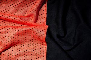 Sport clothing fabric texture background. Top view of red polyester nylon cloth textile surface. Colored basketball shirt with free space for text photo