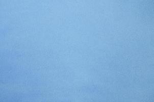 The blanket of furry blue fleece fabric. A background texture of light blue soft plush fleece material photo