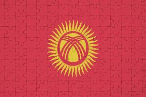 Kyrgyzstan flag is depicted on a folded puzzle photo