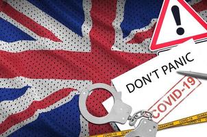 Great britain flag and police handcuffs with inscription Don't panic on white paper. Coronavirus or 2019-nCov virus concept photo