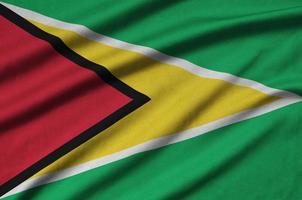 la bandera de guyana está representada en una tela deportiva con muchos pliegues. bandera del equipo deportivo foto