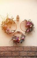 Decoration urban art object from bicycle wheels and flowers on wall photo