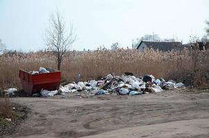 el bote de basura está lleno de basura y desechos. retiro intempestivo de basura en zonas pobladas foto