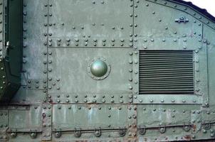 Texture of tank side wall, made of metal and reinforced with a multitude of bolts and rivets photo