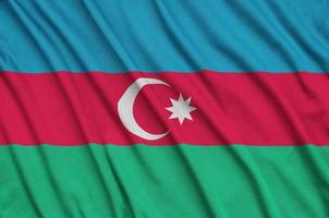 Azerbaijan flag is depicted on a sports cloth fabric with many folds. Sport team banner photo