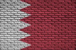 Bahrain flag is painted onto an old brick wall photo