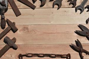 A set of old and rusty tools lies on a wooden table in the workshop photo