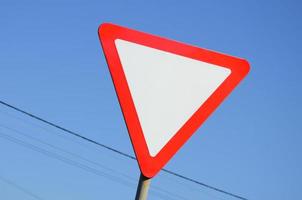 Traffic sign in the form of a white triangle. Give way photo