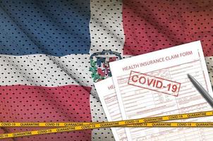 Dominican Republic flag and Health insurance claim form with covid-19 stamp. Coronavirus or 2019-nCov virus concept photo