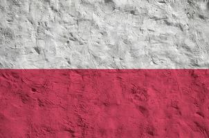 Poland flag depicted in bright paint colors on old relief plastering wall. Textured banner on rough background photo