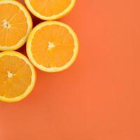 Top view of a several orange fruit slices on bright background in orange color. A saturated citrus texture image photo