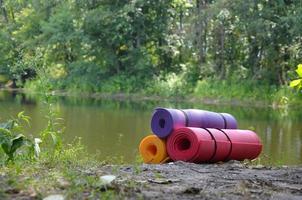 Yoga, fitness or tourist mats on the green grass outdoors photo