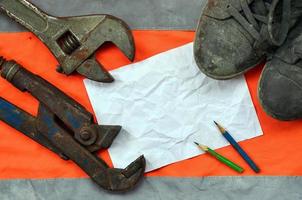 Adjustable wrenches with old boots and a sheet of paper with two photo