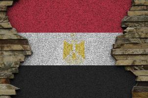 Egypt flag depicted in paint colors on old stone wall closeup. Textured banner on rock wall background photo