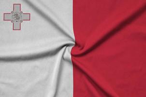 Malta flag is depicted on a sports cloth fabric with many folds. Sport team banner photo