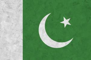 Pakistan flag depicted in bright paint colors on old relief plastering wall. Textured banner on rough background photo