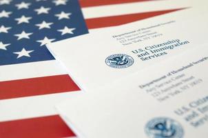 Envelopes with letter from USCIS on United States flag from Department of Homeland Security photo