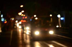 Blurred night scene of traffic on the roadway. Defocused image of cars traveling with luminous headlights. Bokeh Art photo