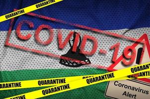 Lesotho flag and Covid-19 quarantine yellow tape with red stamp. Coronavirus or 2019-nCov virus photo