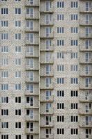 patrón texturizado de una pared de construcción de casas residenciales de piedra blanca rusa con muchas ventanas y balcón en construcción foto