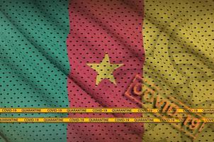 Cameroon flag and orange Covid-19 stamp with border tape. Coronavirus or 2019-nCov virus concept photo