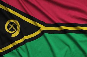 Vanuatu flag is depicted on a sports cloth fabric with many folds. Sport team banner photo