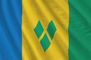 Saint Vincent and the Grenadines flag with big folds waving close up under the studio light indoors. The official symbols and colors in banner photo