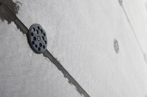 The texture of the wall, covered with gray foam polystyrene plates, which are reinforced with plastic umbrella dowels. Stage of wall insulation photo