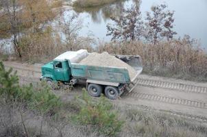 Dump truck transports sand and other minerals in the mining quarry. Heavy industry photo