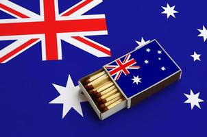 Australia flag is shown in an open matchbox, which is filled with matches and lies on a large flag photo