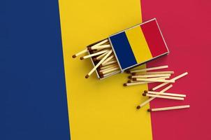 Chad flag is shown on an open matchbox, from which several matches fall and lies on a large flag photo