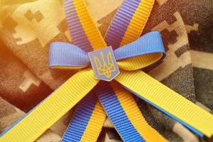 Military camouflage fabric with ukrainian stripes on ribbon photo