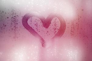 The heart is painted on the misted glass in winter photo