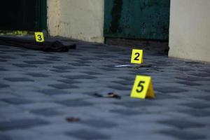 Evidence with yellow CSI marker for evidence numbering on the residental backyard in evening. Crime scene investigation concept photo