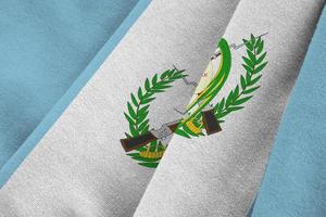 Guatemala flag with big folds waving close up under the studio light indoors. The official symbols and colors in banner photo