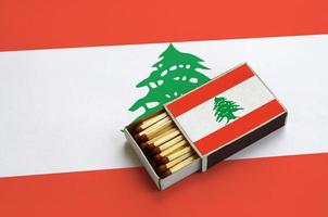 la bandera de líbano se muestra en una caja de fósforos abierta, que está llena de fósforos y se encuentra en una bandera grande foto